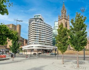 Exterior view of hotel building near historic church and city street at Atlantic Tower Hotel Liverpool By Sunday.