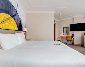 Comfortable double room with large bed, wall art, desk, and TV at Atlantic Tower Hotel Liverpool By Sunday.