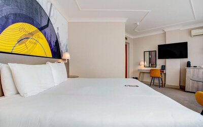 Comfortable double room with large bed, wall art, desk, and TV at Atlantic Tower Hotel Liverpool By Sunday.