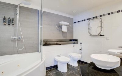 Large bathroom with bathtub, walk-in shower, bidet, and modern sink setup at Atlantic Tower Hotel Liverpool By Sunday.