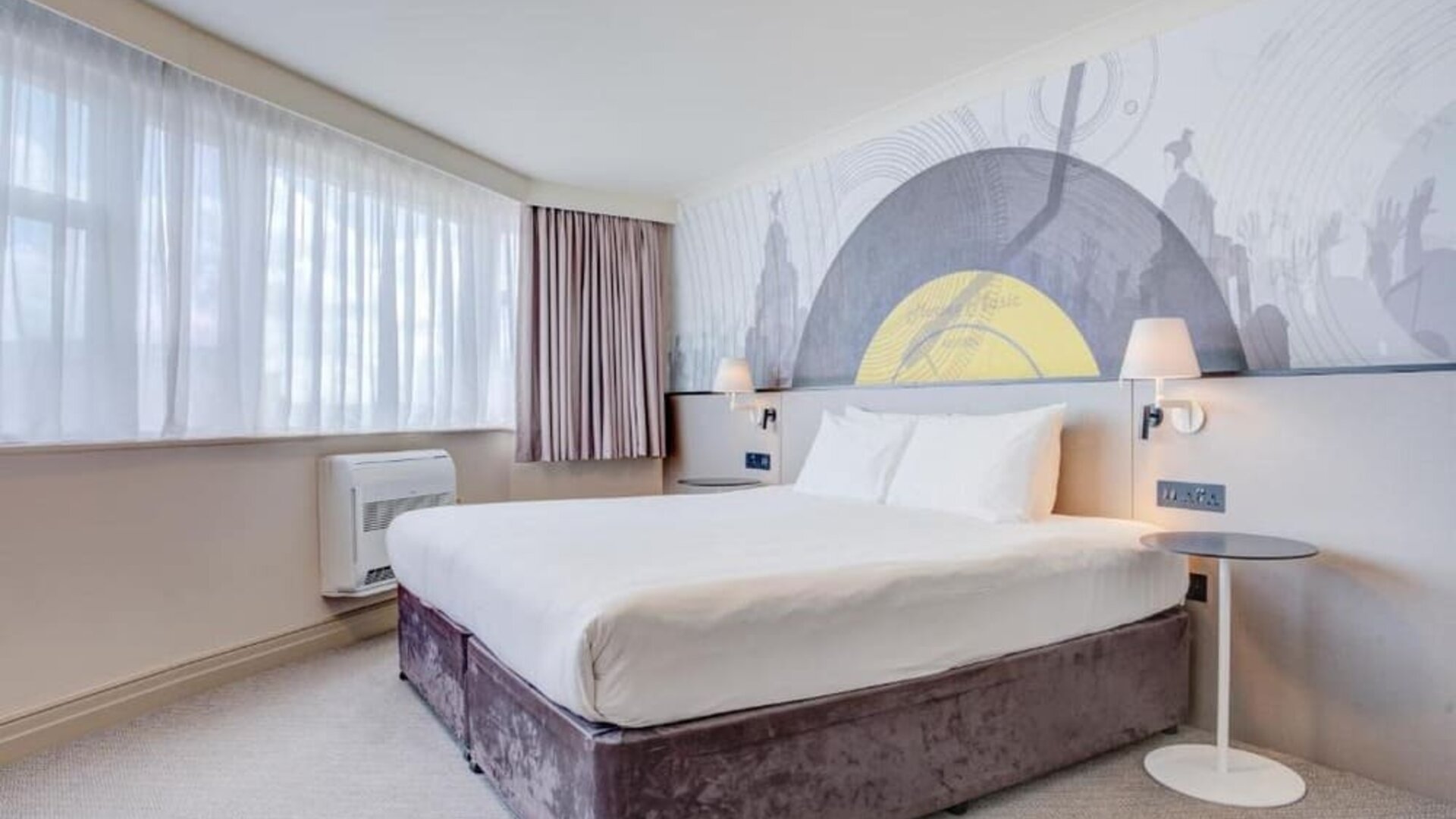 Bright double room with large windows, wall mural, and bedside lighting at Atlantic Tower Hotel Liverpool By Sunday.