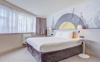 Bright double room with large windows, wall mural, and bedside lighting at Atlantic Tower Hotel Liverpool By Sunday.