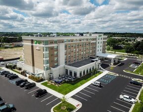 Aerial exterior view with parking lot, landscaped grounds, and hotel building at Holiday Inn & Suites Farmington Hills - Detroit NW By IHG.