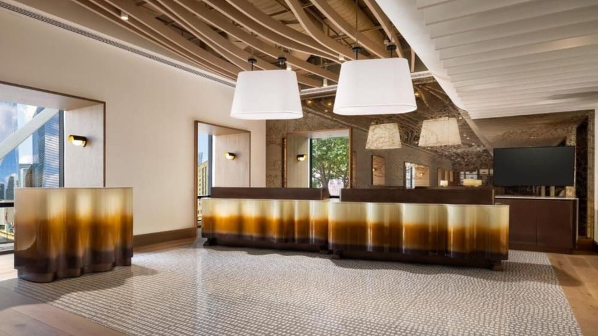 Lobby area with reception desk, modern lighting fixtures, and stylish interior design at M Social New York Downtown.