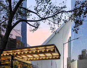 Hotel exterior entrance with covered canopy and surrounding city architecture at M Social New York Downtown.