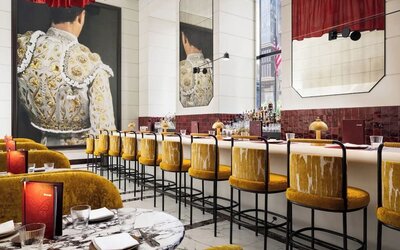 Restaurant bar area with high seating, decorative lighting, mirrors, and curated bar display at M Social New York Downtown.