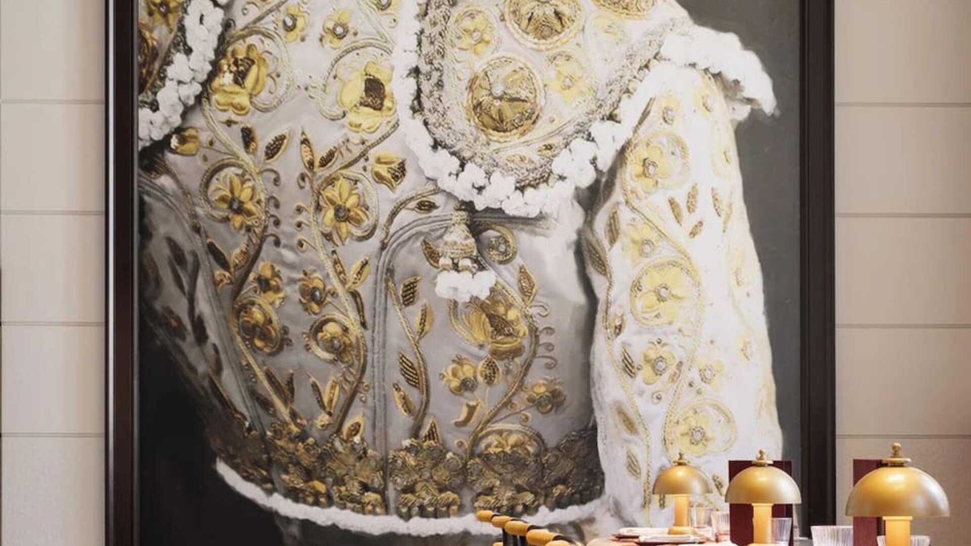 Restaurant interior with bar seating, gold upholstered chairs, marble tables, and large statement artwork at M Social New York Downtown.