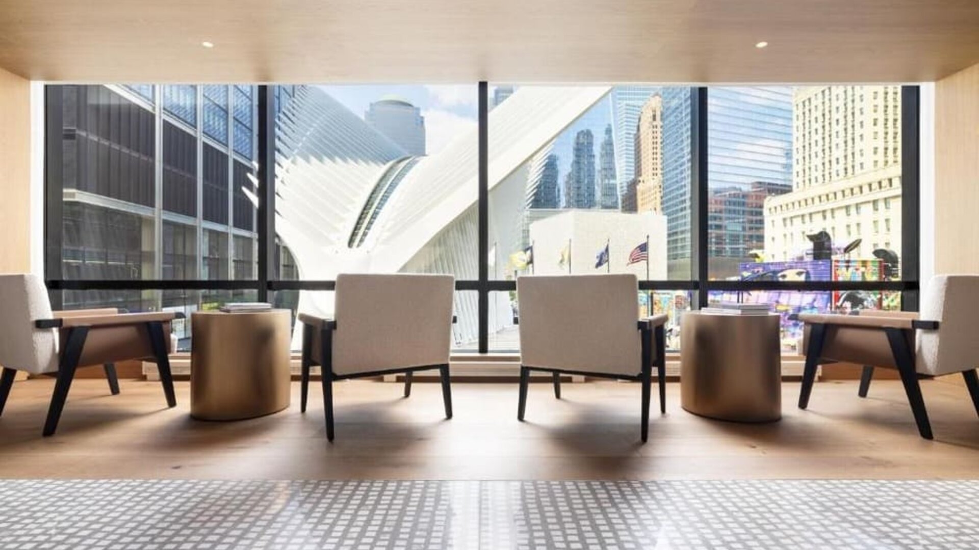 Seating area with large windows overlooking city architecture and natural light-filled space at M Social New York Downtown.