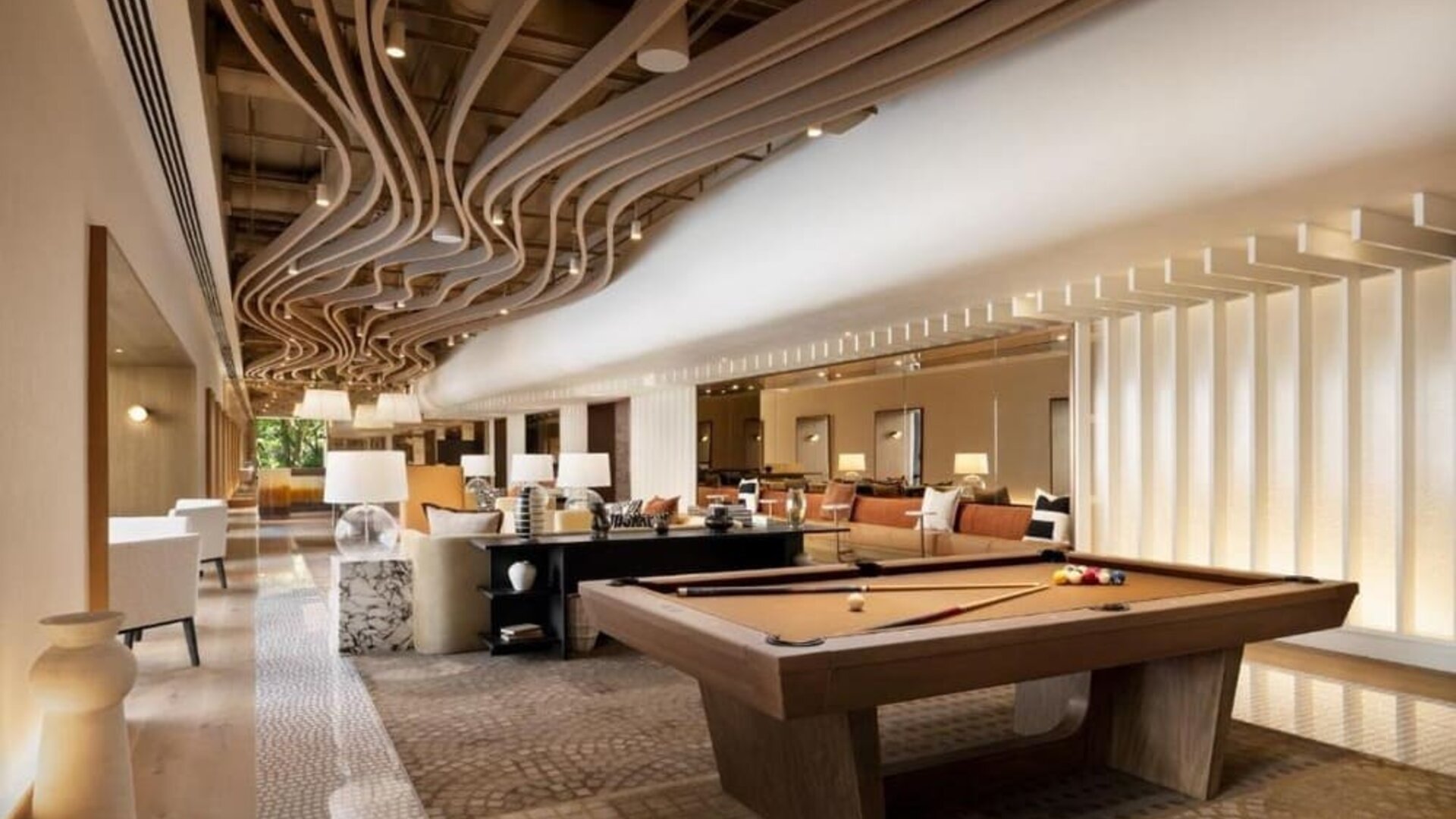 Lounge area with pool table, open seating, and modern ceiling design at M Social New York Downtown.