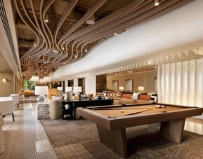 Lounge area with pool table, open seating, and modern ceiling design at M Social New York Downtown.