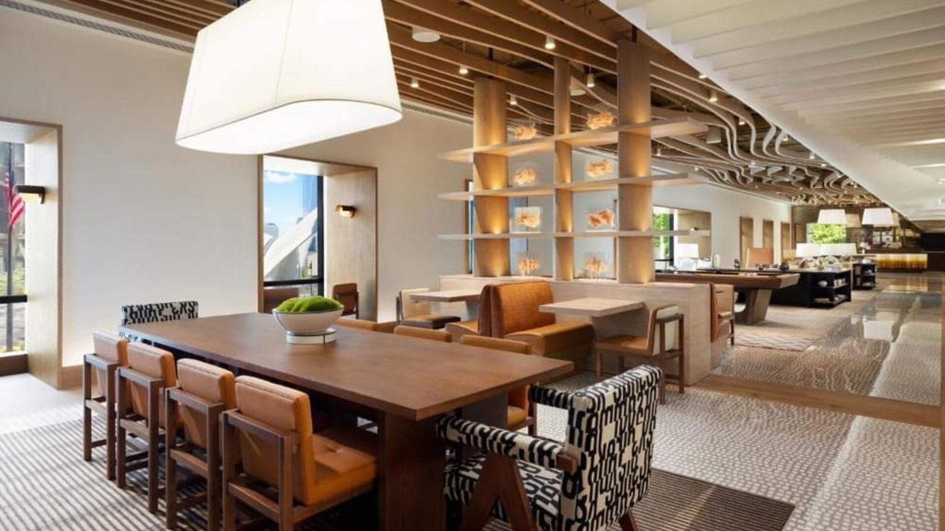 Open lounge and workspace area with communal seating, tables, and modern lighting at M Social New York Downtown.