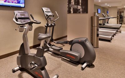 Fitness center with cardio machines including elliptical and exercise bike at Holiday Inn New York City - Times Square By IHG.