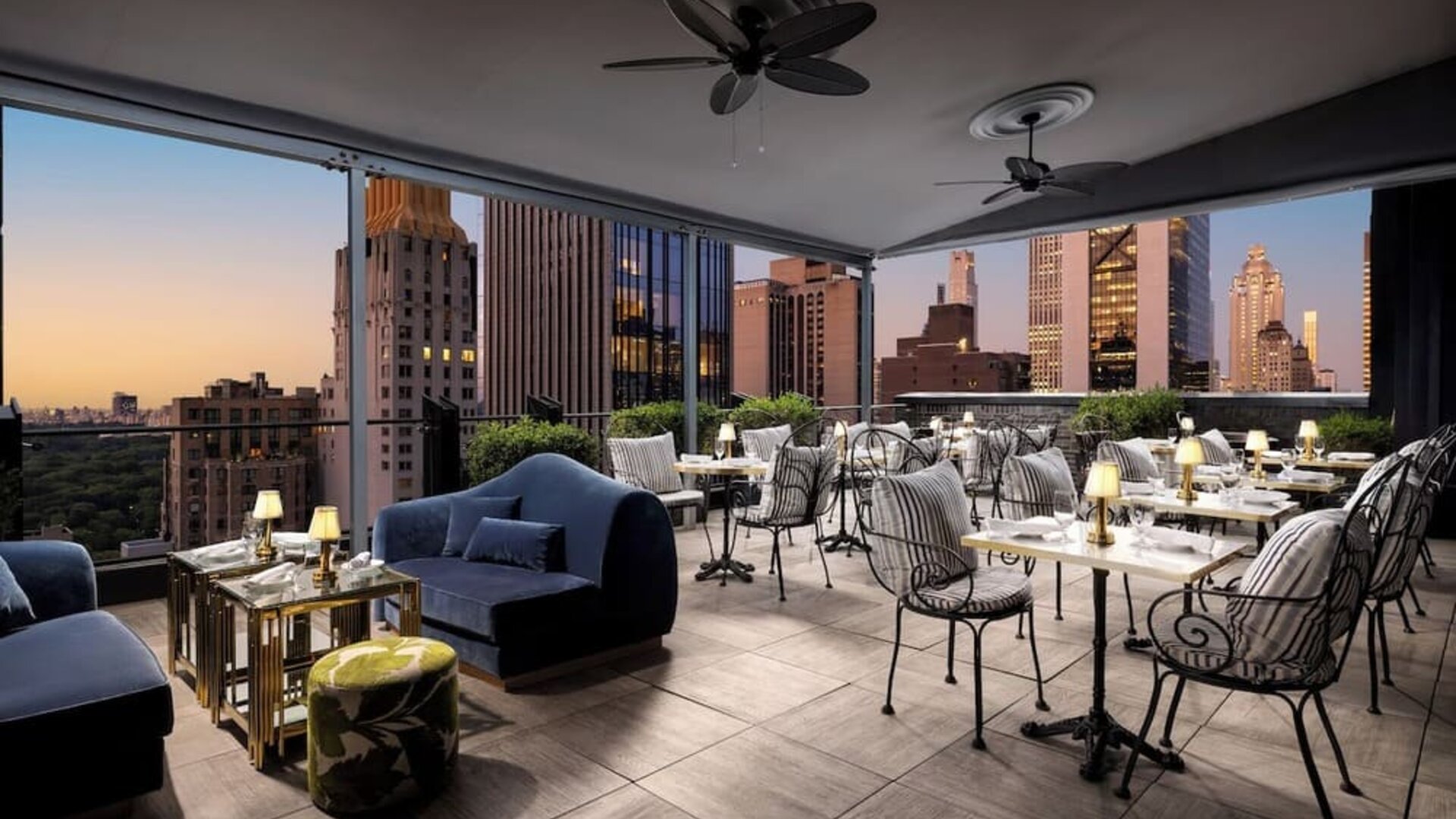 Rooftop terrace with lounge seating, dining tables, and skyline views at Le Méridien New York, Central Park.