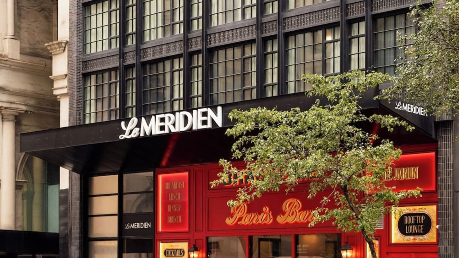 Exterior entrance with Le Méridien signage and Paris Baguette storefront at Le Méridien New York, Central Park.