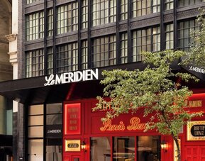 Exterior entrance with Le Méridien signage and Paris Baguette storefront at Le Méridien New York, Central Park.