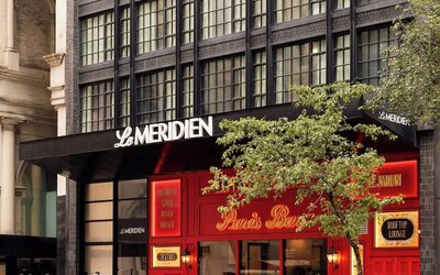 Exterior entrance with Le Méridien signage and Paris Baguette storefront at Le Méridien New York, Central Park.