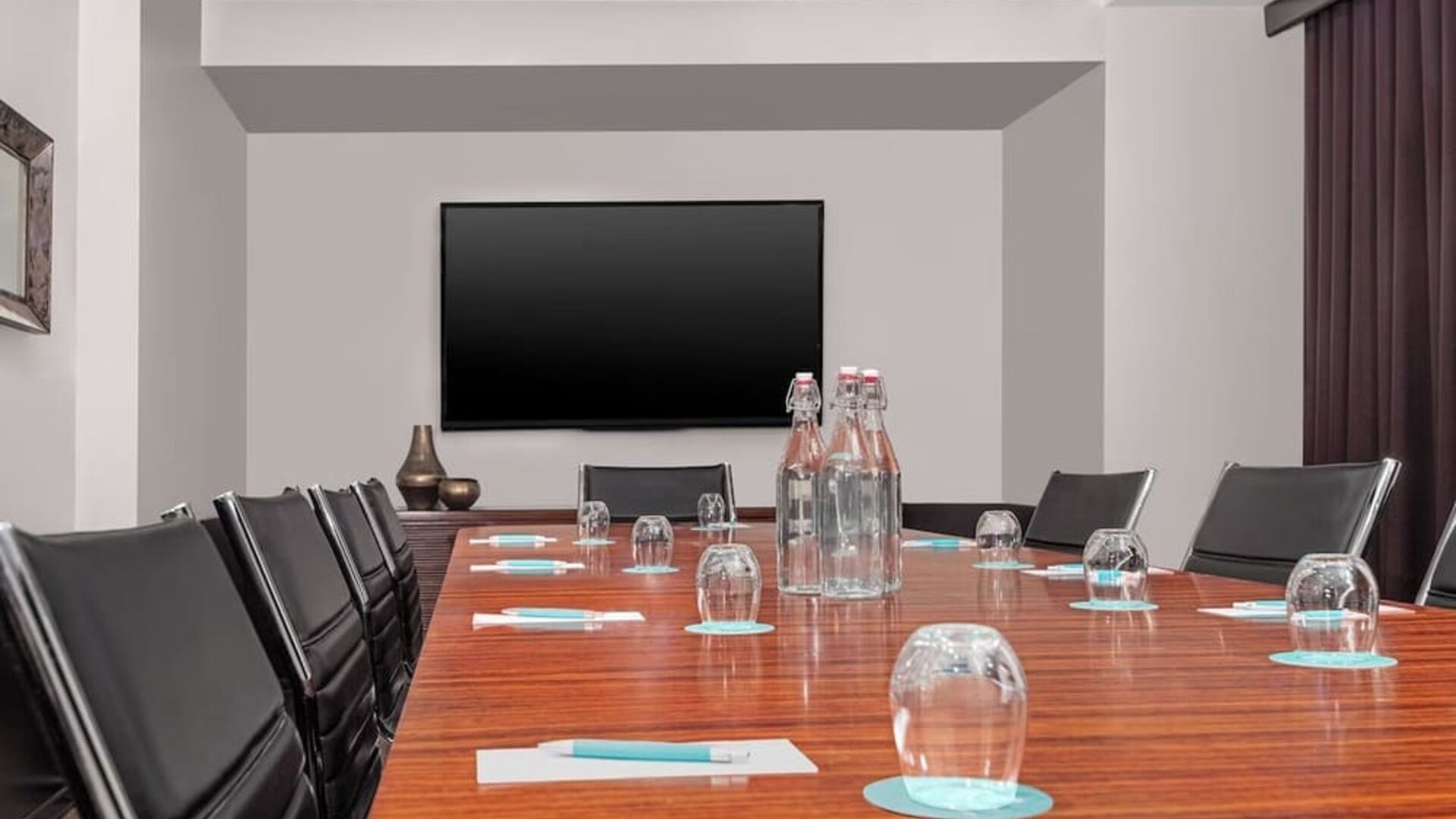 Meeting room with conference table, chairs, and presentation screen at Le Méridien New York, Central Park.