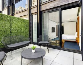 Private balcony with outdoor seating and access to guest room at Le Méridien New York, Central Park.