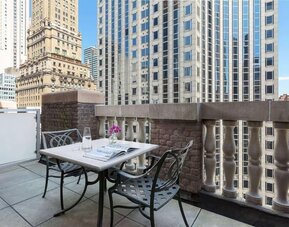 Private balcony with outdoor seating and city views at Hotel 57.