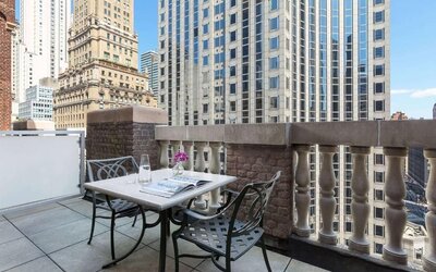 Private balcony with outdoor seating and city views at Hotel 57.