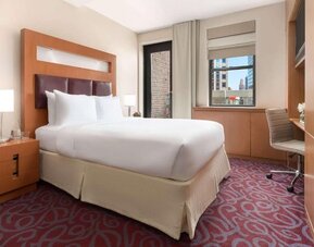 Guest room with king bed, workspace, and balcony access at Hotel 57.