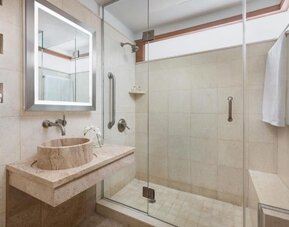 Bathroom with walk-in shower and modern stone finishes at Hotel 57.