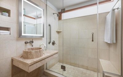 Bathroom with walk-in shower and modern stone finishes at Hotel 57.