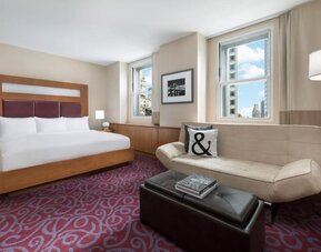 Guest room with sofa seating and natural light at Hotel 57.