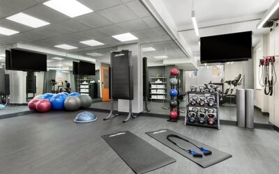Fitness center with mats, weights, and training equipment at Hotel 57.
