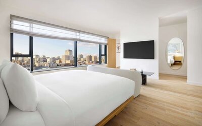 Bright modern room with large bed, floor-to-ceiling windows, and city views at Timbri Hotel San Francisco, Curio Collection By Hilton.