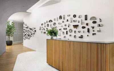 Reception area with wooden desk, artistic wall installation, and minimalist design at Timbri Hotel San Francisco, Curio Collection By Hilton.