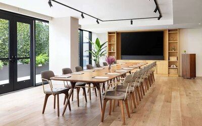 Conference room with long table, chairs, and presentation setup at Timbri Hotel San Francisco, Curio Collection By Hilton.