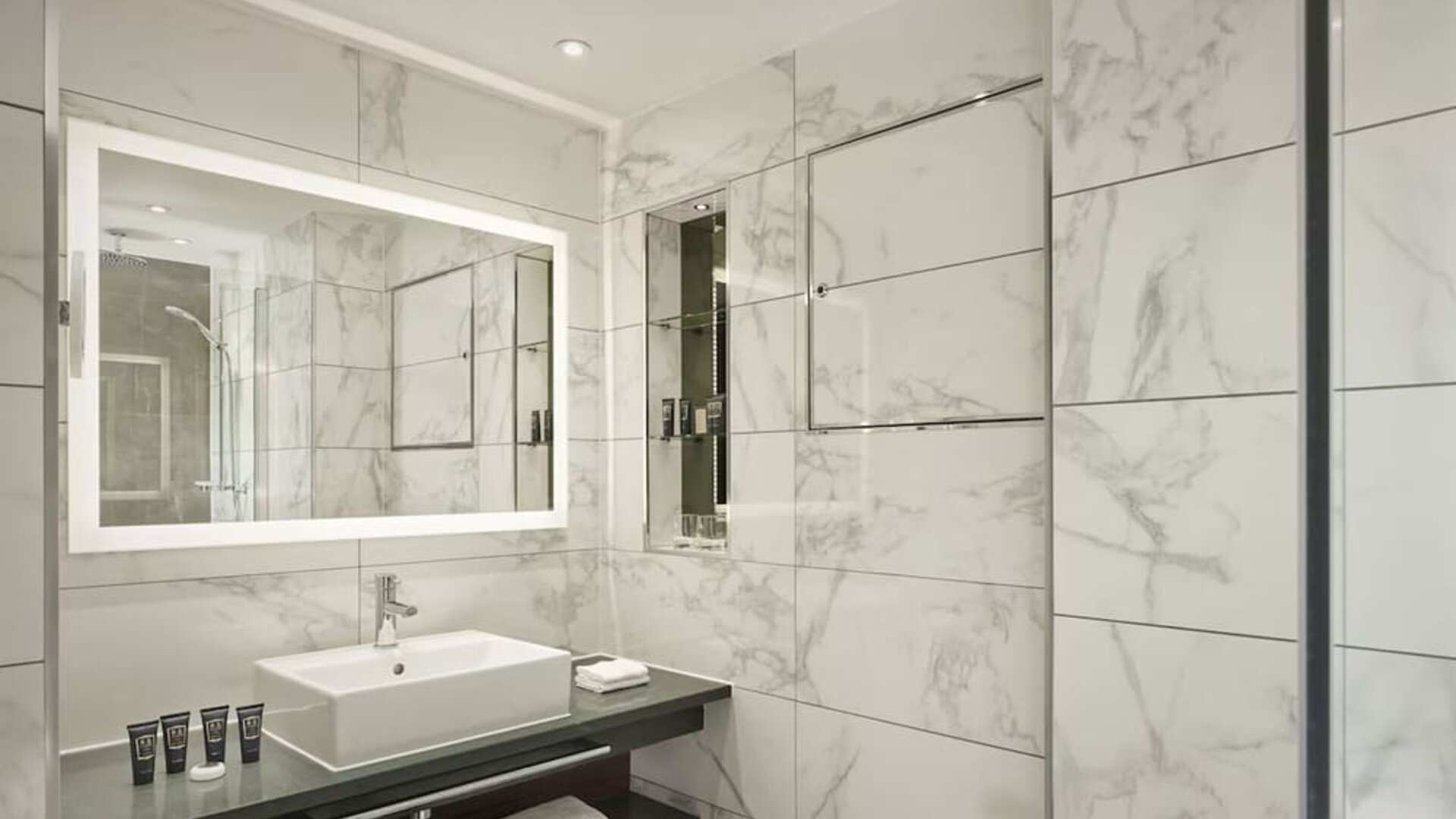 Guest bathroom with shower, mirror, and basin at 100 Queen's Gate Hotel London.