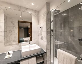 Guest bathroom with shower, mirror, and basin at 100 Queen's Gate Hotel London.