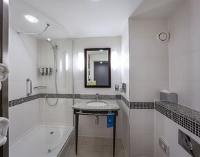 Guest bathroom with bath and shower at Hampton By Hilton Liverpool/John Lennon Airport.