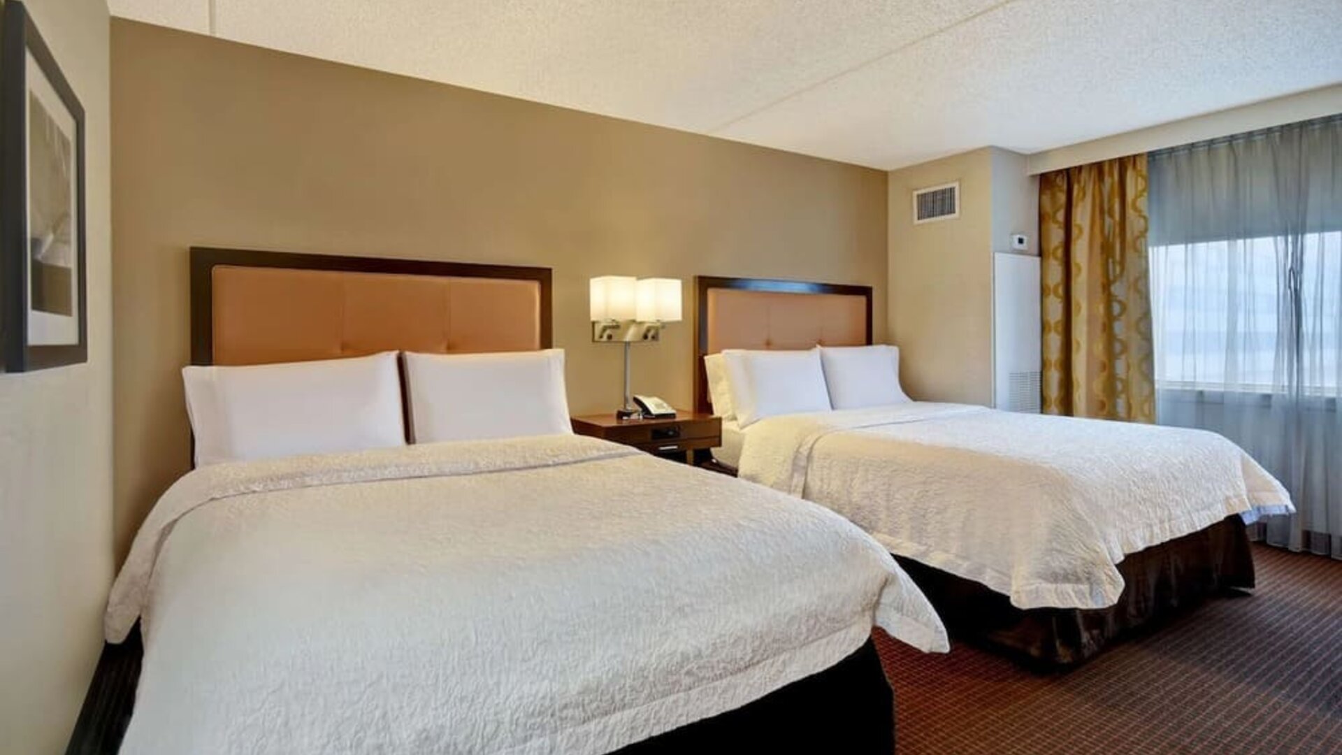Two queen beds with natural light at Hampton Inn NY-JFK.