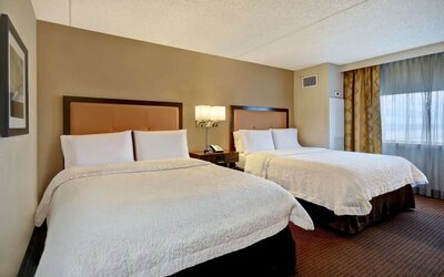 Two queen beds with natural light at Hampton Inn NY-JFK.