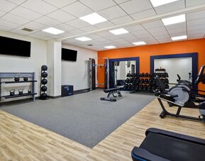Fitness center with treadmills and weights at Hampton Inn NY-JFK.
