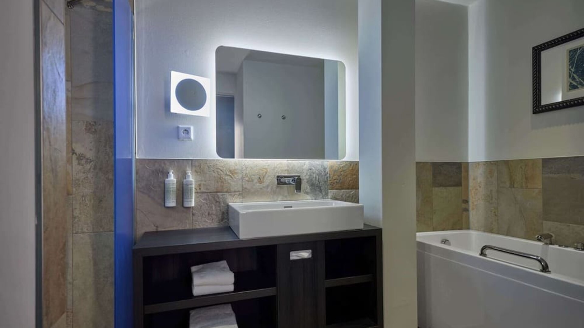 Guest bathroom with bath and shower at Haven Hotel Rotterdam.