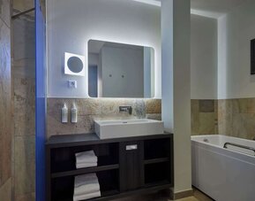 Guest bathroom with bath and shower at Haven Hotel Rotterdam.