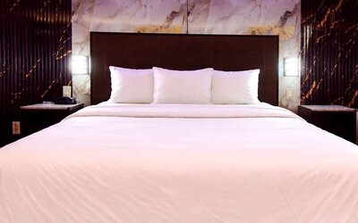 King room with sleek headboard, marble accent wall, and soft LED lighting for a contemporary feel at Imperial Hotel.