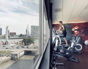 Fitness center with canal views at DoubleTree By Hilton Rotterdam Centre.