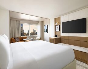 King room with bed, desk, and seating area near window at Hyatt Regency Times Square.