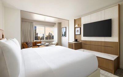 King room with bed, desk, and seating area near window at Hyatt Regency Times Square.