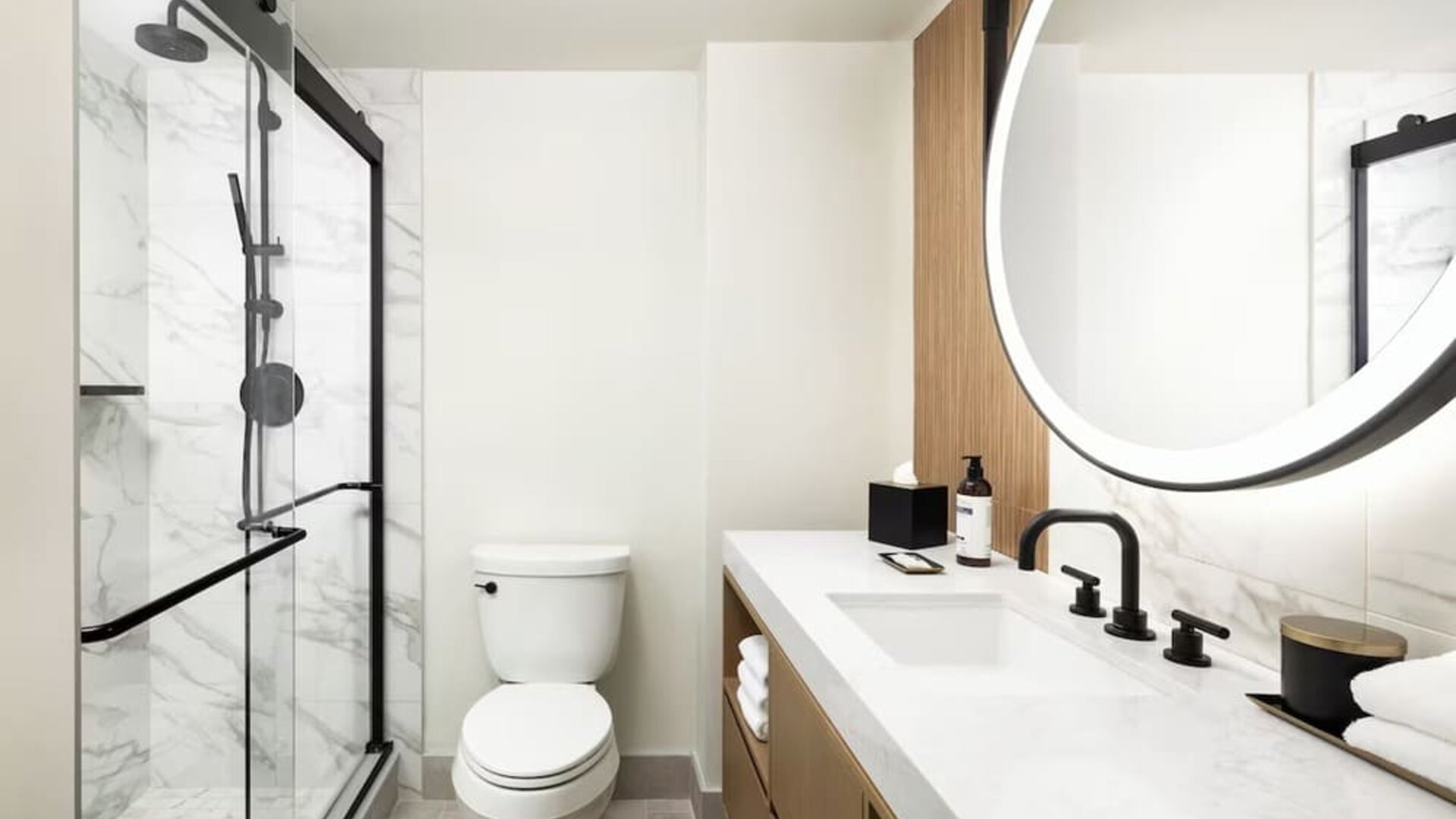 Modern bathroom with glass-enclosed shower, marble walls, and vanity at Hyatt Regency Times Square.