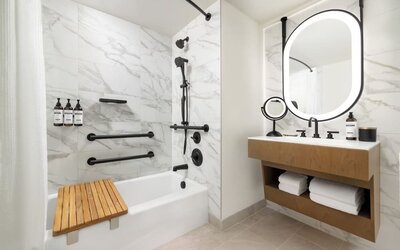 Bathroom with bathtub, shower fixtures, and marble tile finishes at Hyatt Regency Times Square.