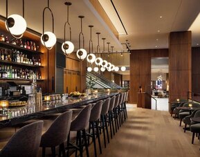 Bar area with seating, pendant lighting, and full-service counter at Hyatt Regency Times Square.