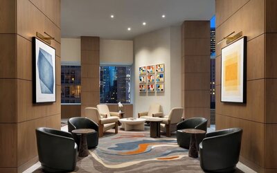Lobby seating area with modern chairs, artwork, and warm lighting at Hyatt Regency Times Square.