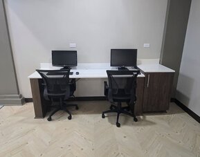 Business center with dual workstations, desktop computers, and ergonomic seating at Wyndham Garden Williamsburg Busch Gardens Area.