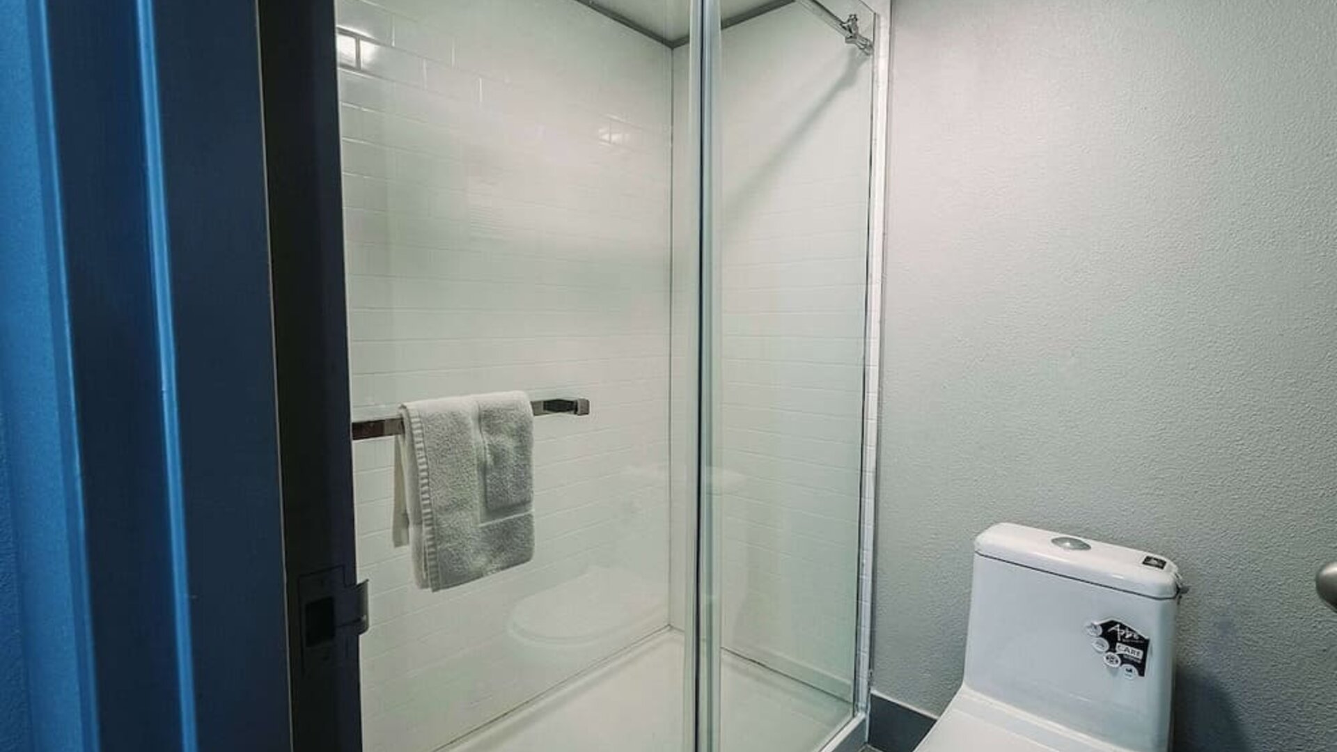 Bathroom with glass-enclosed shower, tiled walls, and modern fixtures at Wyndham Garden Williamsburg Busch Gardens Area.